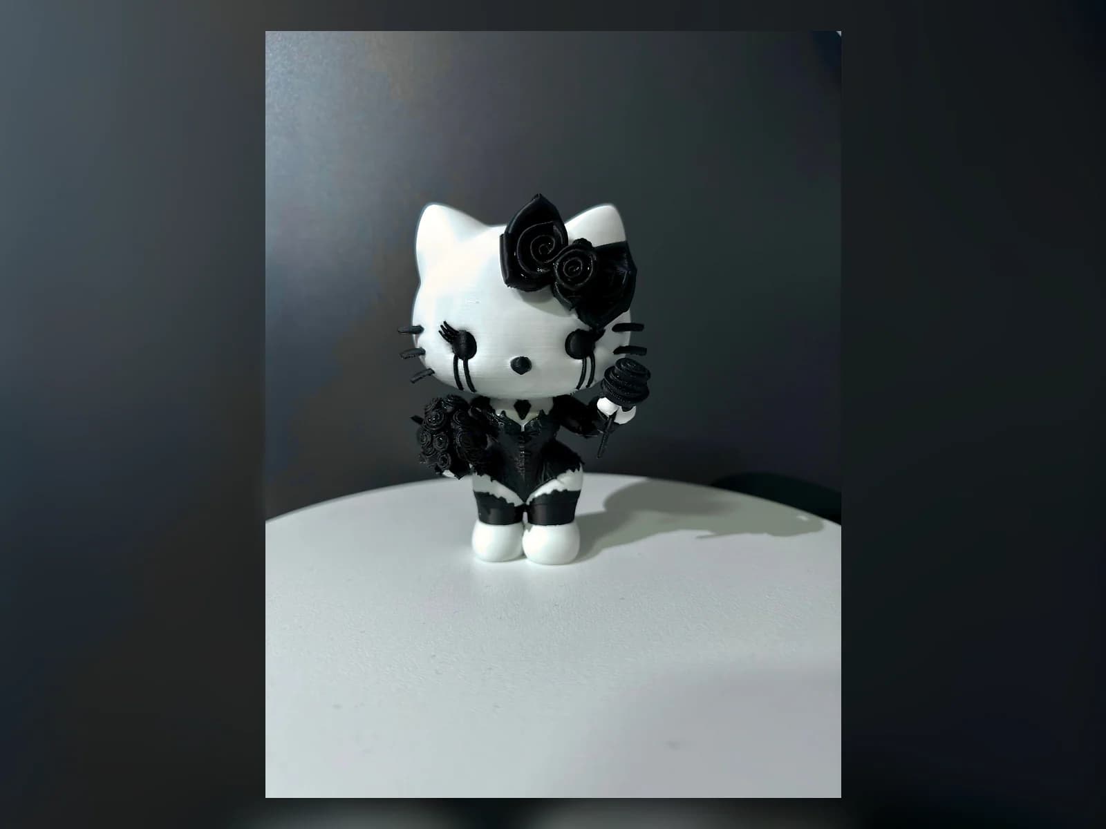 Fekete-fehér figura fekete ruházattal és rózsadísszel